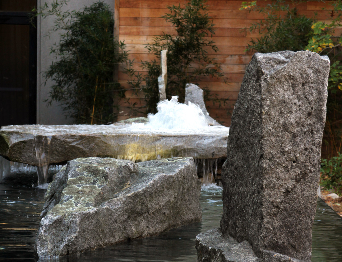 Negative edge water feature with found art stones