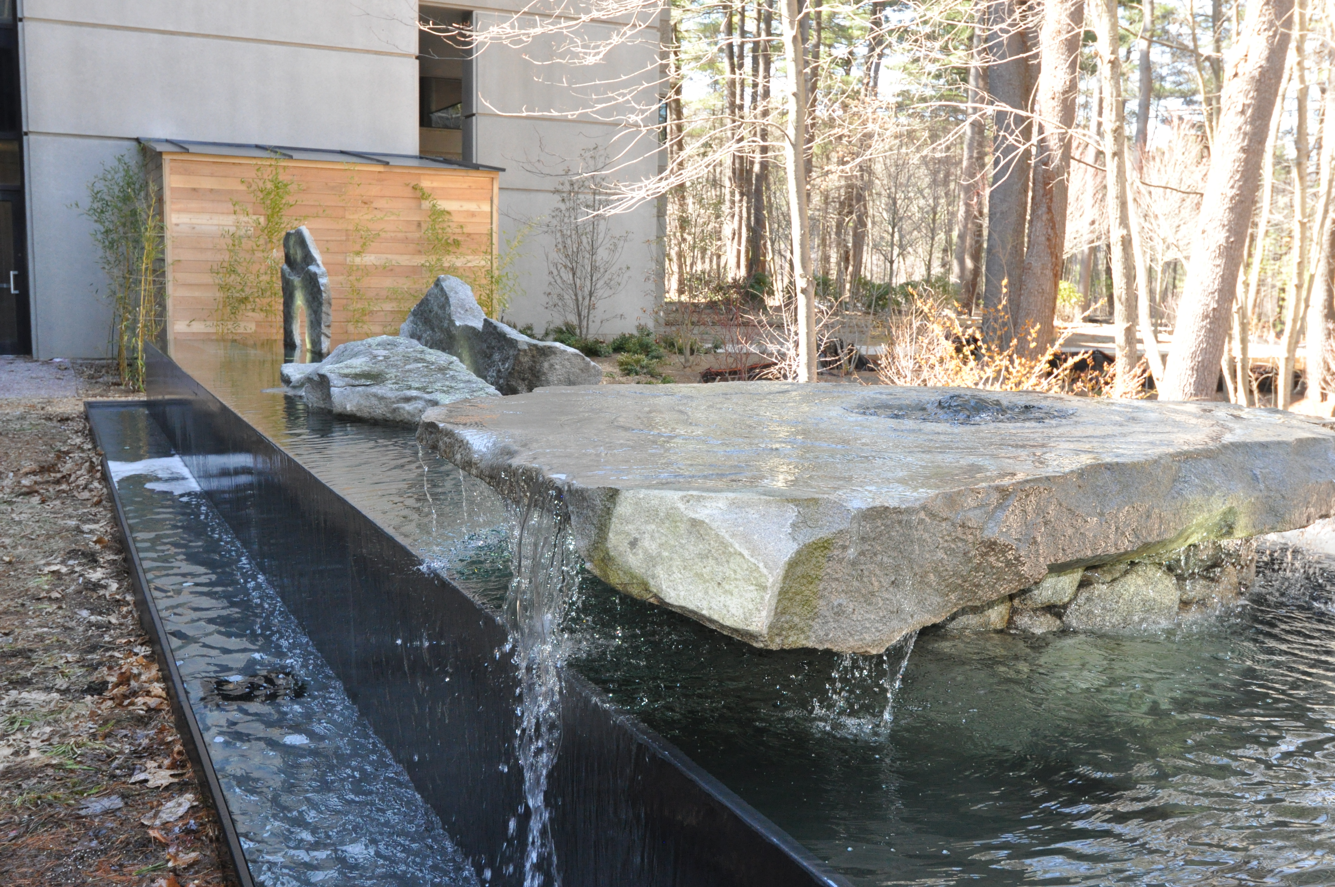 Negative edge water feature with found art stones, Oracle, Bedford MA. Design by Thomas Wirth Associates. Architectural Stones by Lew French.